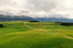 montaña picos y pradera son debajo blanco nubes foto