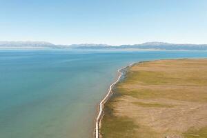 lago y pradera con un soleado día. Disparo en sayram lago en Xinjiang, porcelana. foto