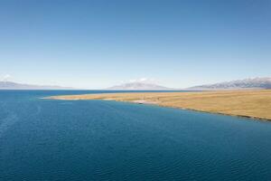 lago y pradera con un soleado día. Disparo en sayram lago en Xinjiang, porcelana. foto