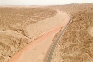 Dryness land with erosion terrain with highway crossing. photo