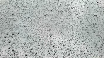 un soltar de agua en el capucha de el coche. agua gotas después lluvia o coche lavar foto