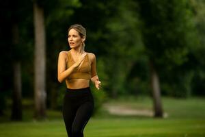 bonito joven mujer corriendo en el parque foto