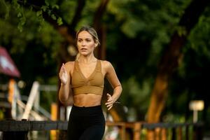 bonito joven mujer corriendo en el carril en el parque foto