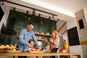 Young family preparing vegetables in the kitchen photo