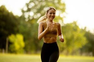 bonito joven mujer corriendo en el parque foto