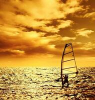 Silhouette windsurfer over sunset photo