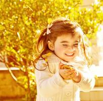 Happy little girl in autumn park photo