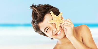 Happy face boy with starfish on the beach photo