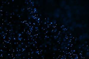 Flowing and glowing particles with dark background, 3d rendering photo