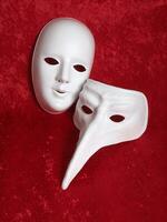 two plain white masks on red velevet photo