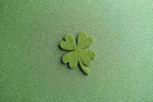 four-leaf clover made from felt on green sparkling background photo