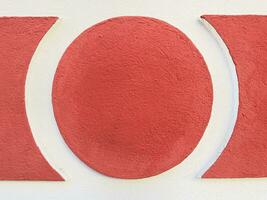 stucco circle or round frame textured wall background in red and white photo