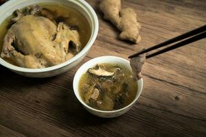 Chicken soup and wooden background. photo