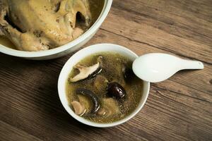 Chicken soup and wooden background. photo