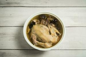 Chicken soup and wooden background. photo