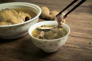 Chicken soup and wooden background. photo