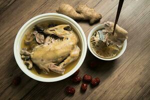 Chicken soup and wooden background. photo