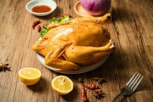 Roast chicken on the wooden table photo