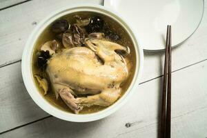 Chicken soup and wooden background. photo