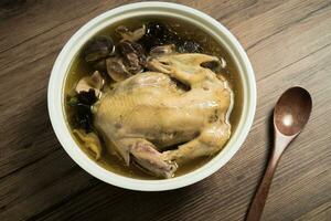 Chicken soup and wooden background. photo