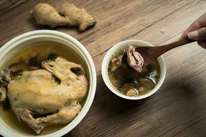 Chicken soup and wooden background. photo