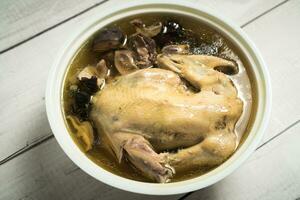 Chicken soup and wooden background. photo