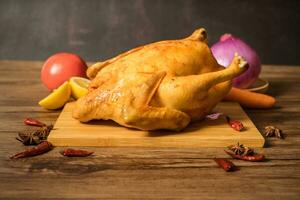 Roast chicken on the wooden table photo