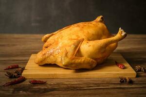 Roast chicken on the wooden table photo