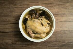 Chicken soup and wooden background. photo