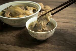 Chicken soup and wooden background. photo