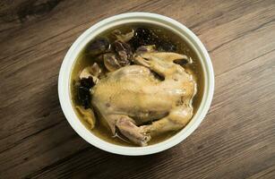 Chicken soup and wooden background. photo