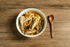 Chicken soup and wooden background. photo