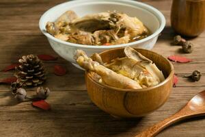 Chicken soup and wooden background. photo