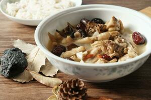 Chicken soup with wooden background photo