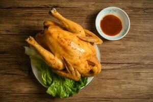 Roast chicken on the wooden table photo