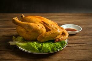 Roast chicken on the wooden table photo