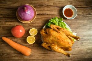 Roast chicken on the wooden table photo