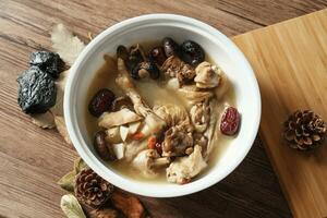 Chicken soup with wooden background photo