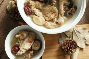 Chicken soup with wooden background photo