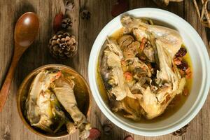 Chicken soup and wooden background. photo