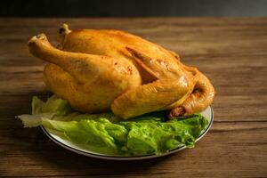 Roast chicken on the wooden table photo