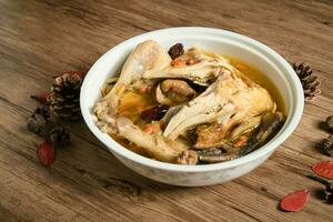 Chicken soup and wooden background. photo