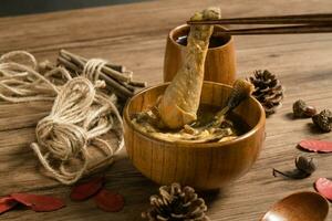 Chicken soup and wooden background. photo