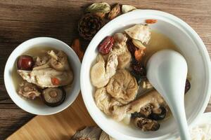 Chicken soup with wooden background photo