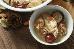 Chicken soup with wooden background photo