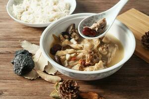 Chicken soup with wooden background photo