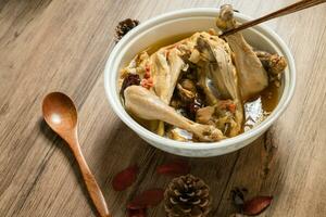 Chicken soup and wooden background. photo