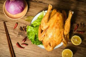 Roast chicken on the wooden table photo