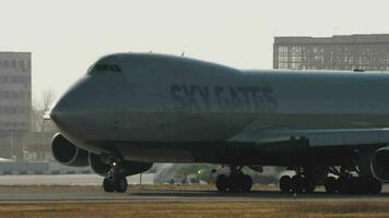 NOVOSIBIRSK, RUSSIAN FEDERATION OCTOBER 20, 2021 - Cargo Boeing 747 Sky Gates Airlines taxiing on the runway at Tolmachevo Airport, Novosibirsk OVB. Jumbo jet, close up. Backlit huge plane video