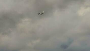 Airliner approaching landing, long shot. Airplane and black smoke. Airplane on the background of stormy dark clouds video